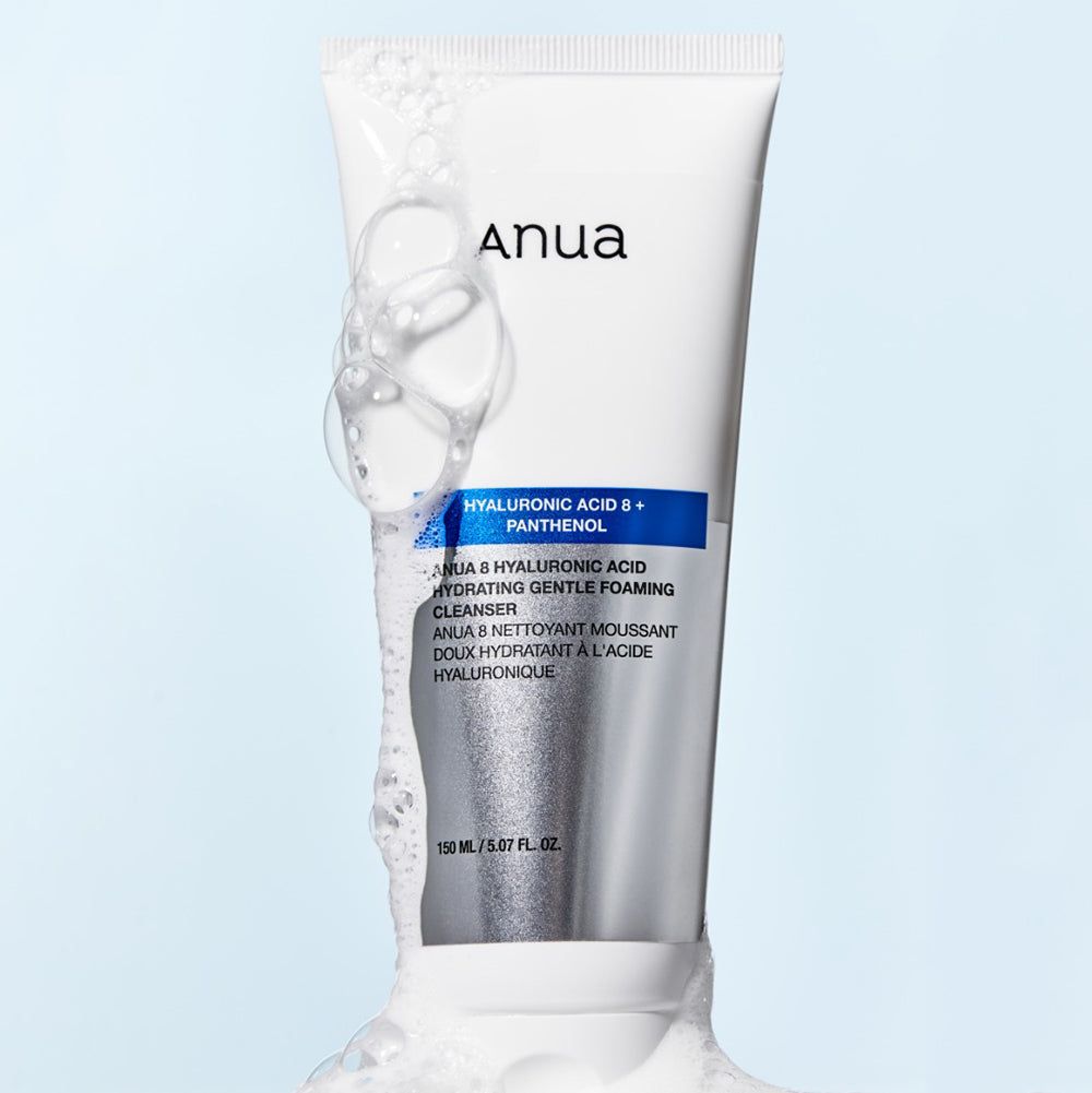 Weiße Tube mit blauem Streifen. Text: „Anua Hyaluronic Acid 8+ Panthenol“. Produkt und Schaum.