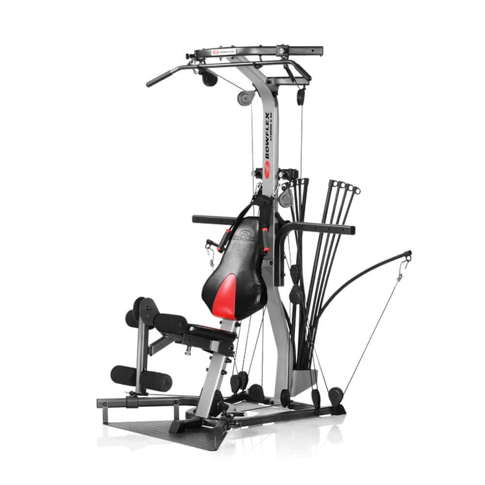 Fitnessgerät. Grauer Metallrahmen mit Seilzügen, Sitz, und schwarzem Boxsack mit rotem Einsatz. Oberhalb ist der Schriftzug Bowflex.