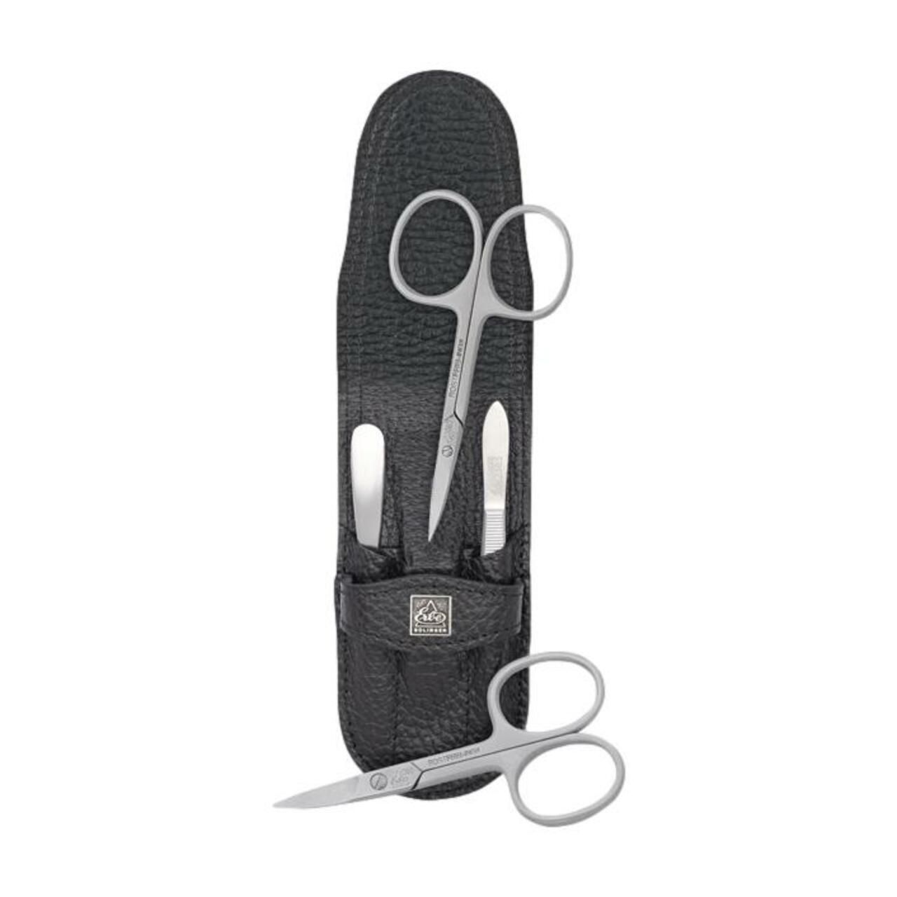Schwarzes Lederetui mit Maniküre-Set: Schere, Nagelfeile und Hautschere. Eine weitere Schere liegt daneben.