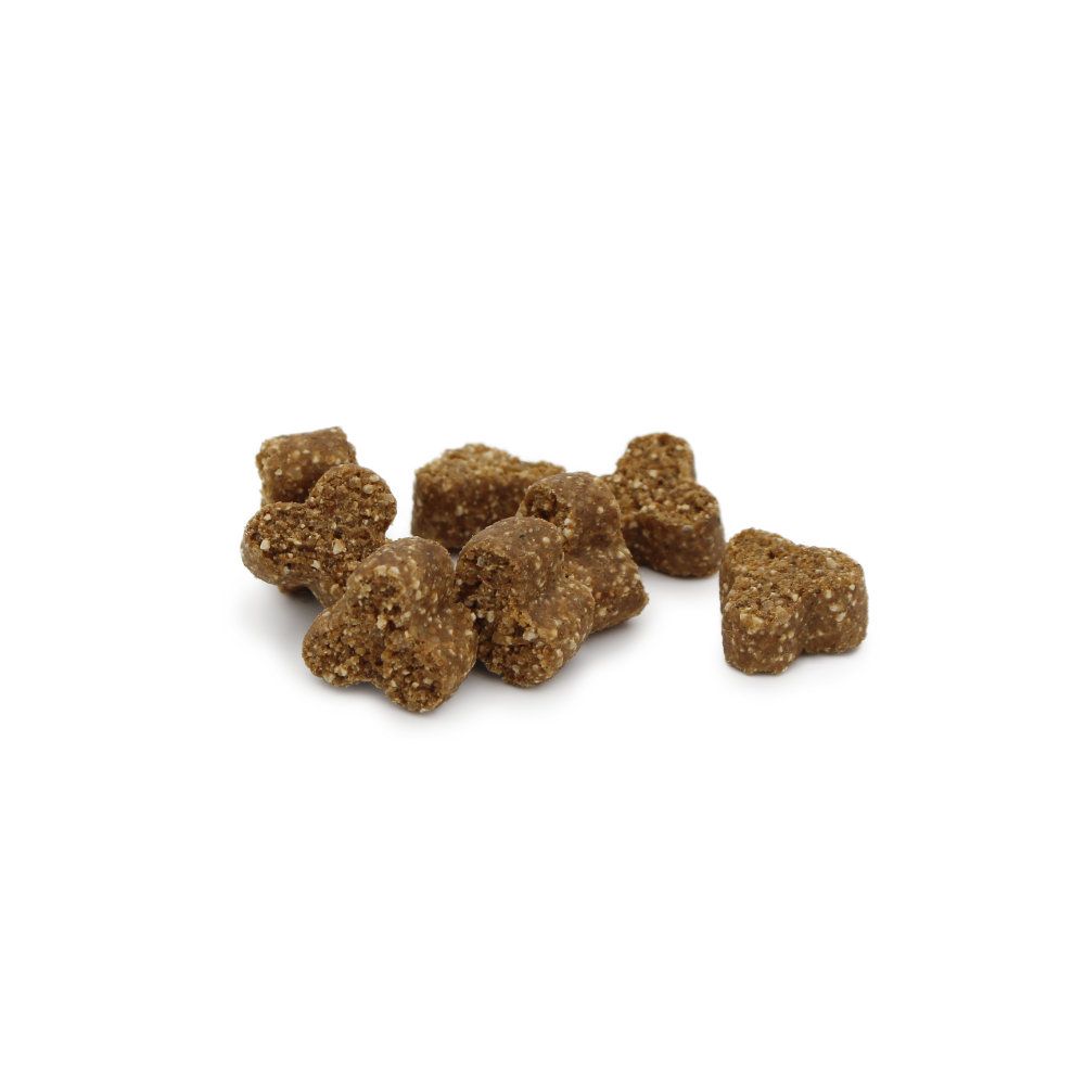 Haufen von braunen, unregelmäßig geformten Leckerlis. Einzelne Stücke sind erkennbar. Hintergrund weiß.