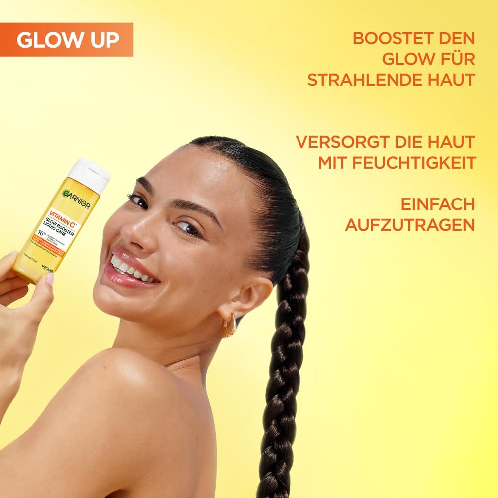 Frau hält Garnier Vitamin C Glow Booster Liquid Care. Gelber Hintergrund. Text: Boostet den Glow für strahlende Haut. Versorgt die Haut.