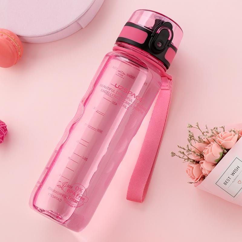 Pinkfarbene Trinkflasche mit schwarzem Deckel. Liegend, mit Messskala und Trageschlaufe.