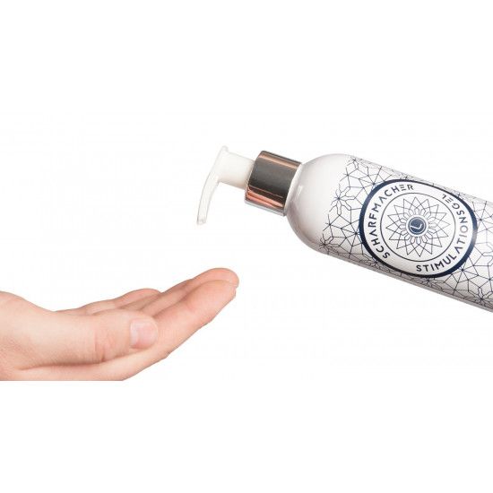 Eine Hand hält eine Flasche Stimulationsgel. Die Flasche hat ein geometrisches Muster und das Logo Lumunu.