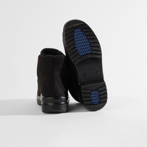 Schwarze Stiefel mit Klettverschluss und rutschfester Sohle.
