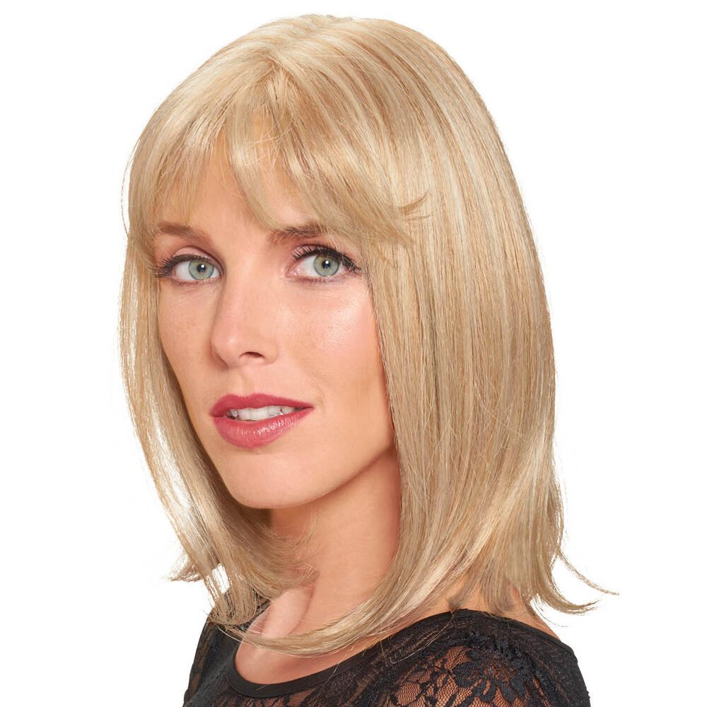 Blondes Haarteil mit Pony. Die Frau trägt ein schwarzes Oberteil. Blick in die Kamera.