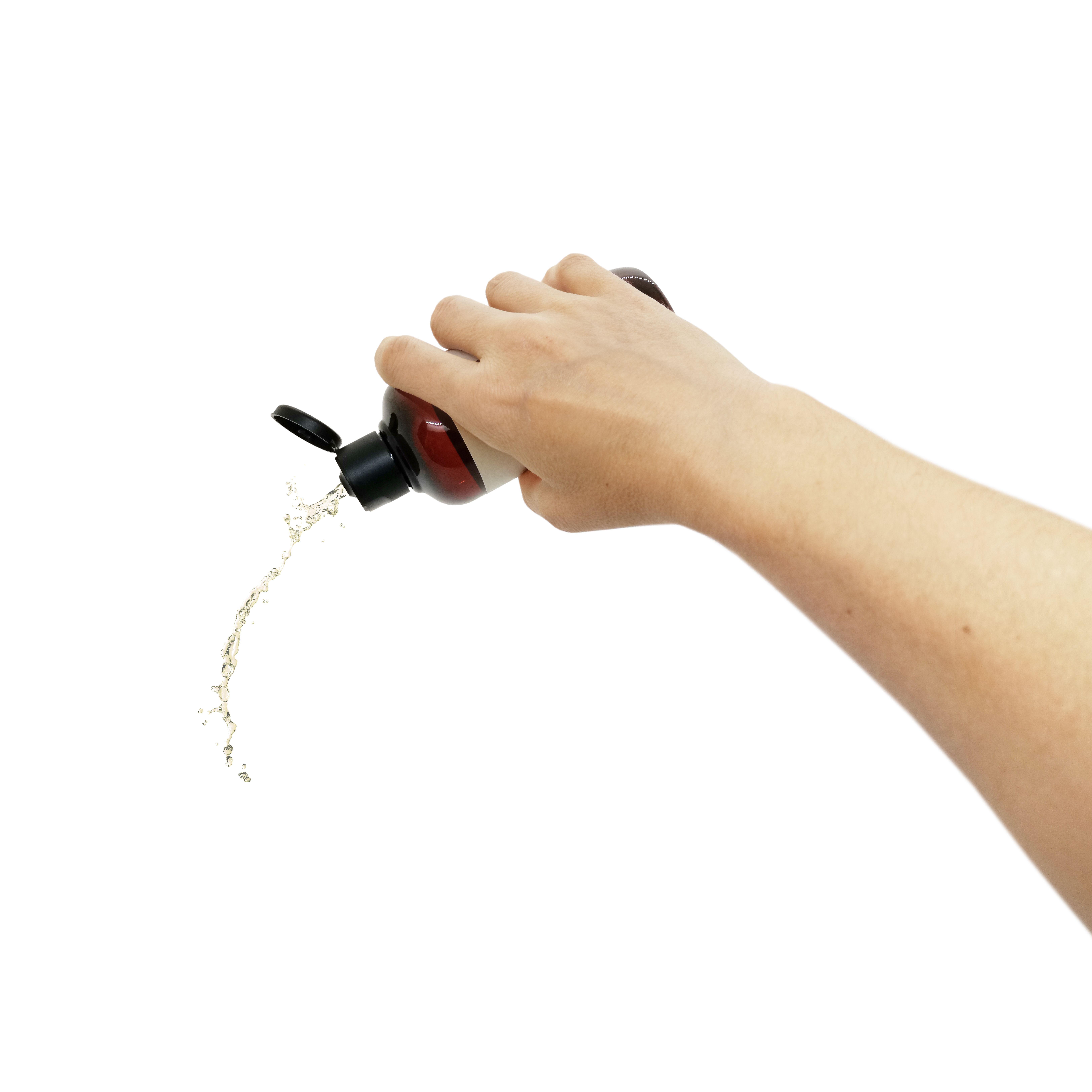 Hand hält eine braune Flasche mit geöffnetem Deckel. Flüssigkeit wird herausgegossen.