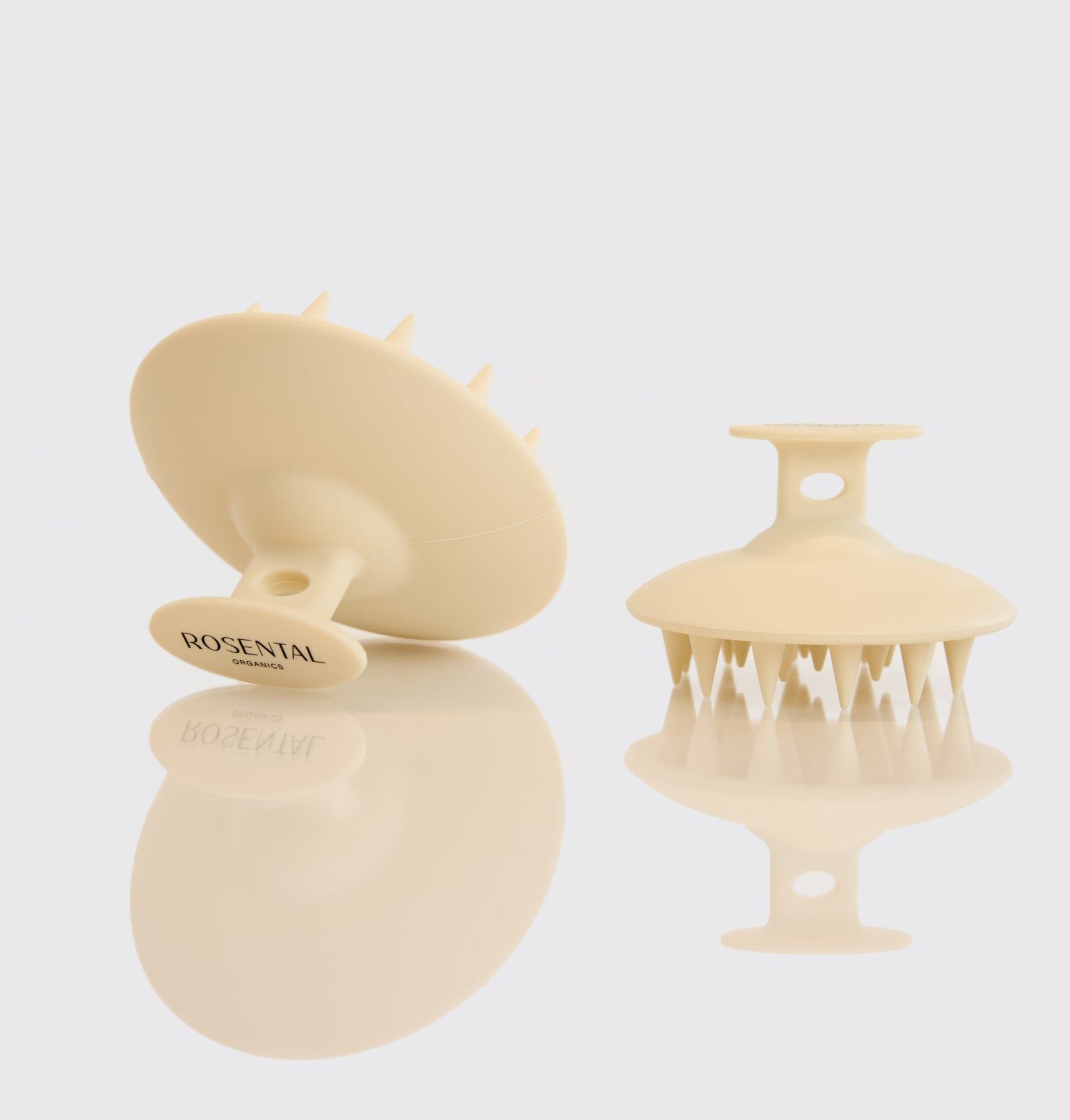 Zwei Kopfhautbürsten. Beige, runde Form mit Griff. Auf einem steht "ROSENTAL".