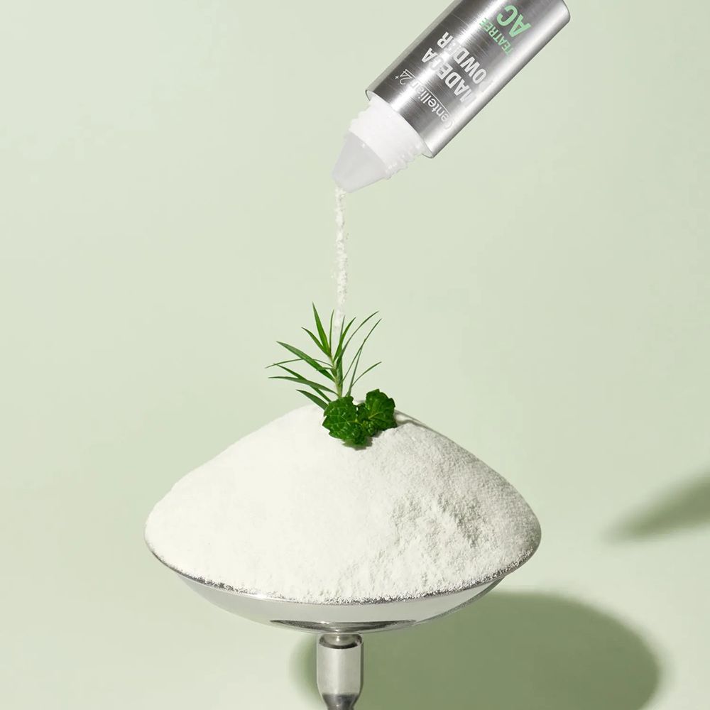 Centellian24 Madeca Powder TeaTree AC Flasche über einem Haufen Pulver.