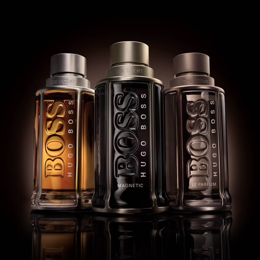 Drei Flakons. BOSS, BOSS Magnetic, BOSS Le Parfum. Goldfarbene, schwarze und braune Flüssigkeiten.