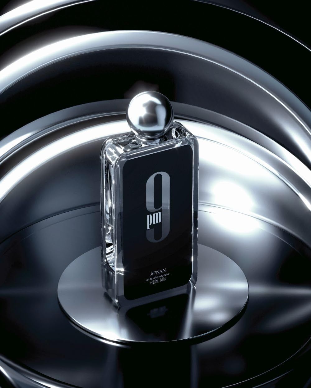 Parfümflasche auf einer Metalloberfläche. Schwarzes Etikett mit weißer Aufschrift '9 pm'. Metallkappe.