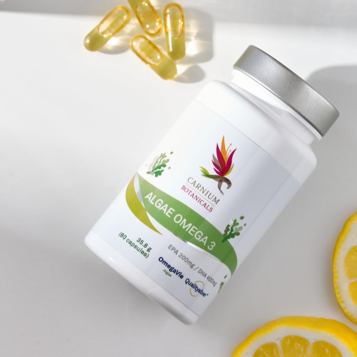 Flasche mit Aufschrift: Carnium Botanicals, Algae Omega 3. Daneben Kapseln und Zitronen. OmegaVie Qualitysilver.