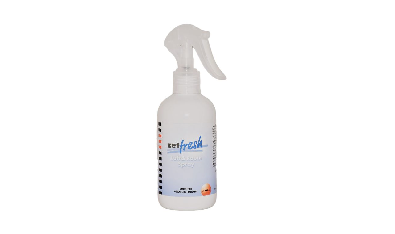 Weiße Sprühflasche mit Sprühkopf. Aufschrift "zetfresh". Etikett mit Text und farbigen Streifen. Produkt für Raumluft.