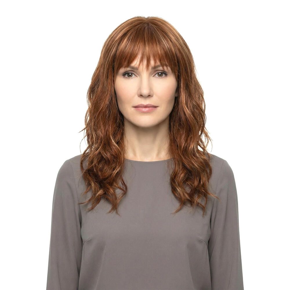 Perücke Kiky von trendhair. Rötlich-braune, gewellte Kunsthaarperücke mit Pony. Frontale Ansicht einer Frau.