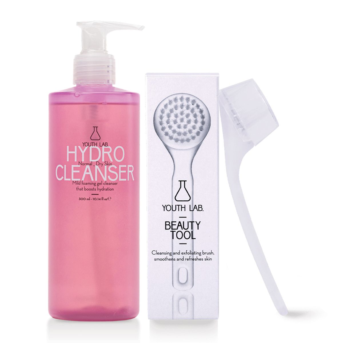 Rosa Flasche und Box mit weißem Pinsel. Aufschrift: HYDRO CLEANSER, BEAUTY TOOL. Pinsel und Flasche stehen nebeneinander.