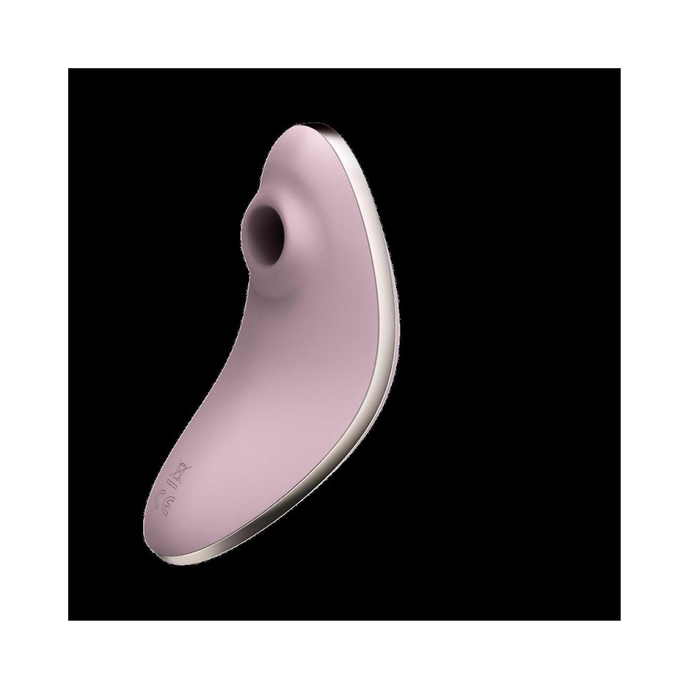 Rosa Vibrator mit silberfarbener Umrandung. Ovale Form mit Öffnung. Auf schwarzem Hintergrund.