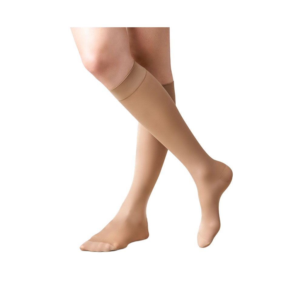 Hautfarbene Kniestrümpfe. Blick von vorne auf die Beine einer Person. Strümpfe reichen bis unter das Knie.