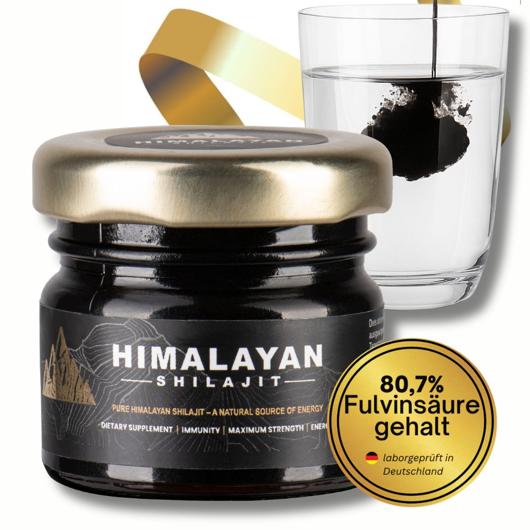 Glas mit Shilajit, Glas mit Wasser, goldene Schleife. Aufschrift: 80,7% Fulvinsäure, Laborgeprüft in Deutschland.