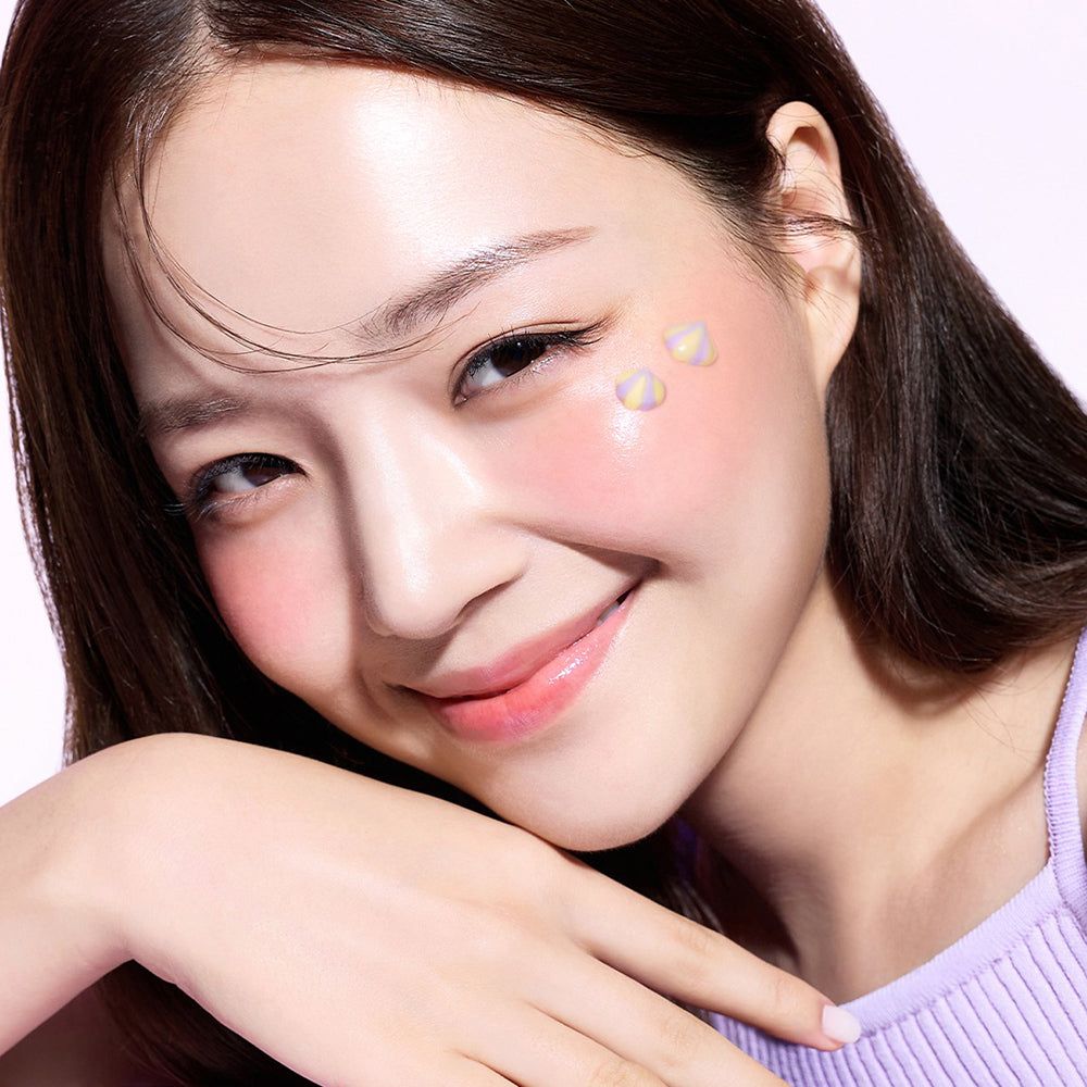 Frau mit Creme auf Wangen. Produktname nicht sichtbar. Haut wirkt rosig und gesund.