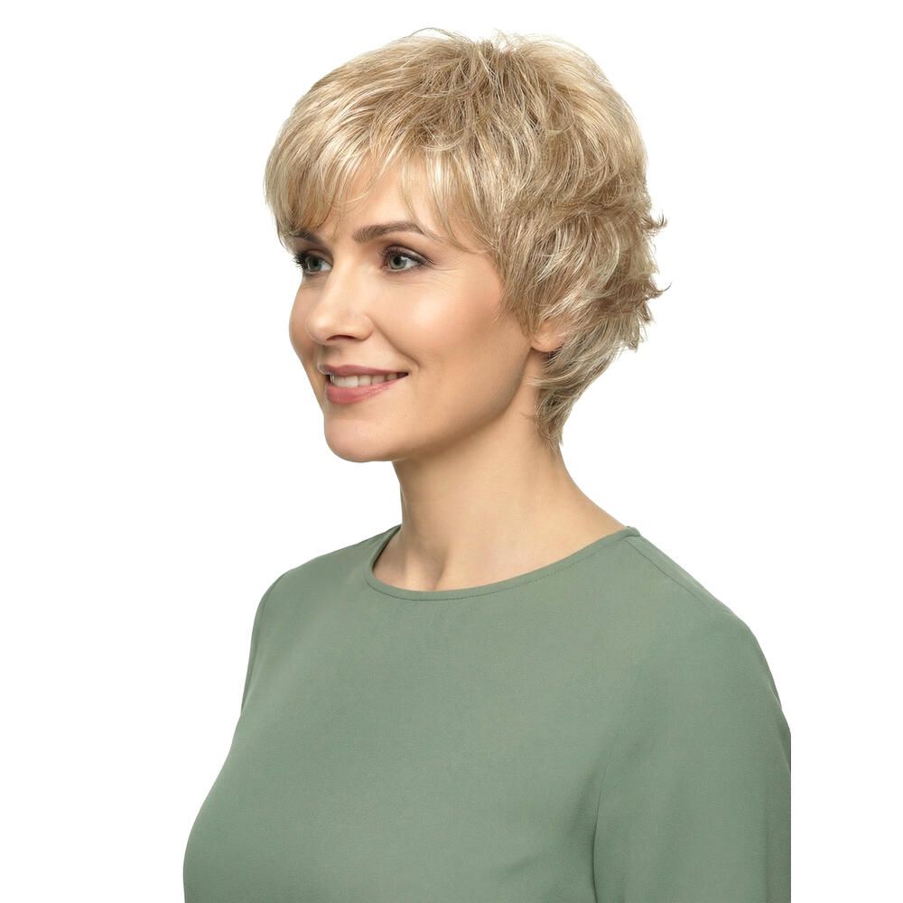 Perücke Ida von Lofty. Blond, kurz geschnitten, gewellt. Frau trägt grünes Oberteil. Seitenansicht.