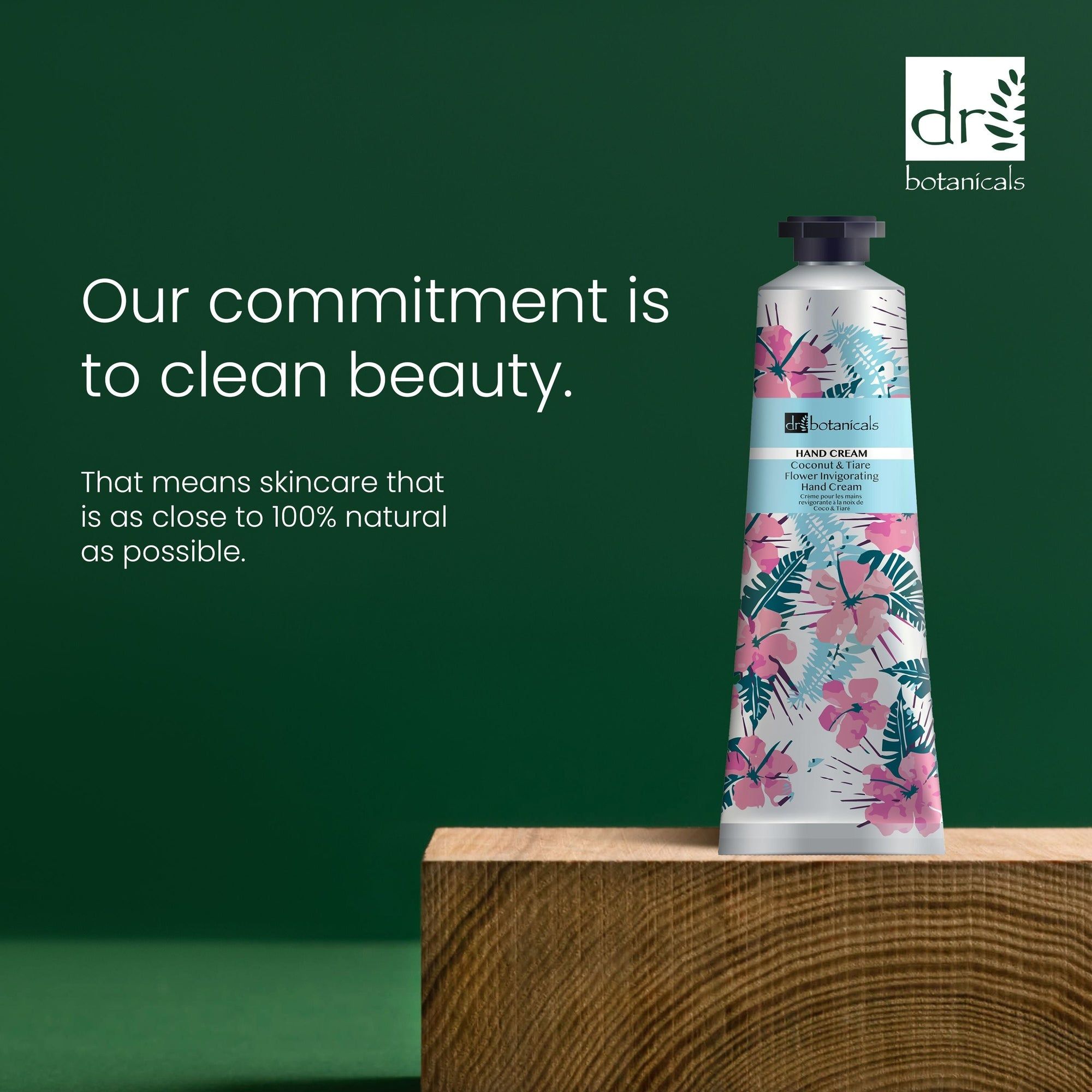 Tube auf Holzblock. Aufschrift: Hand Cream, Coconut & Tiare Flower Invigorating Hand Cream. Text: Our commitment is to clean beauty.