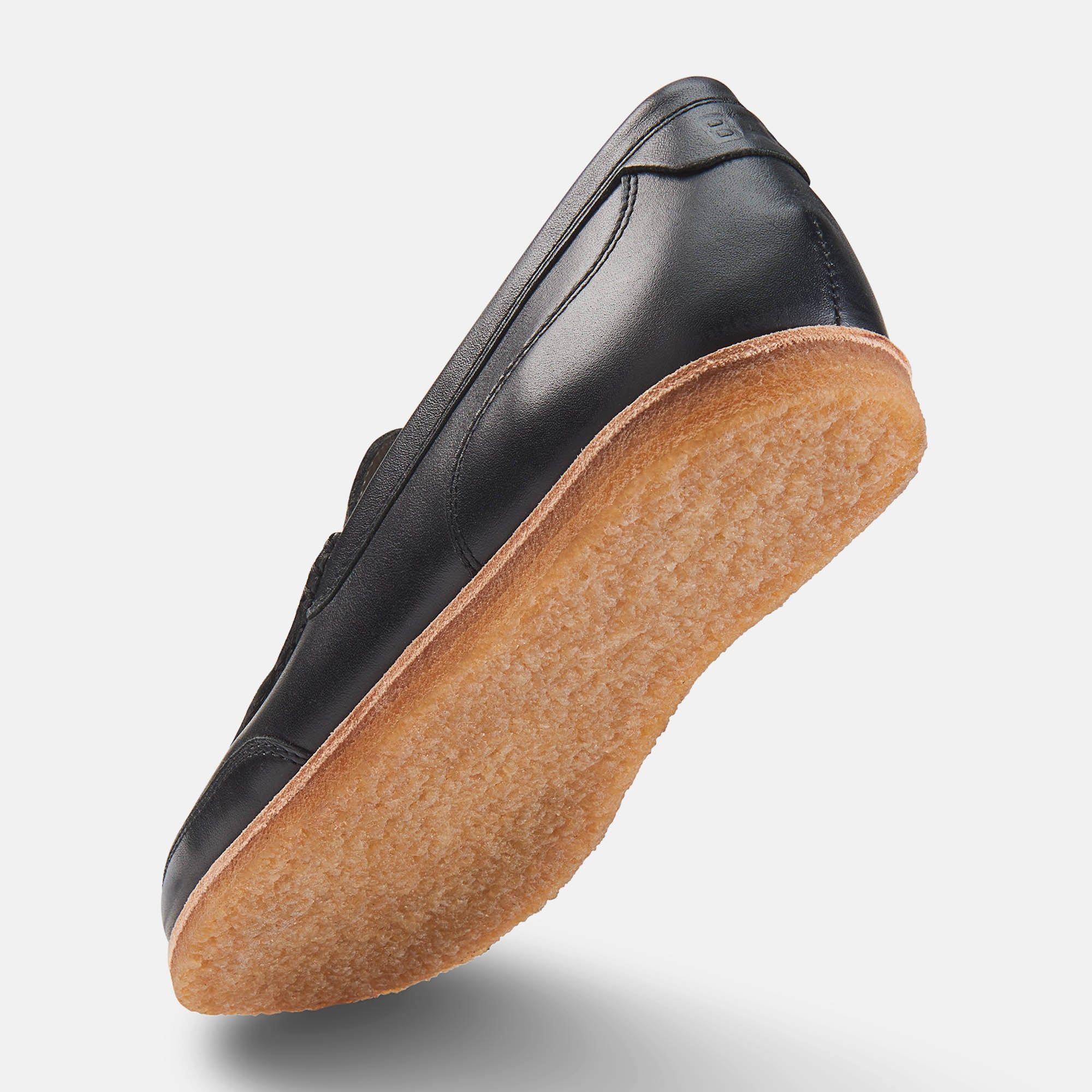 Schwarzer Herren-Slipper mit breiter Passform. Leder-Obermaterial, helle Sohle. Schuh von unten.