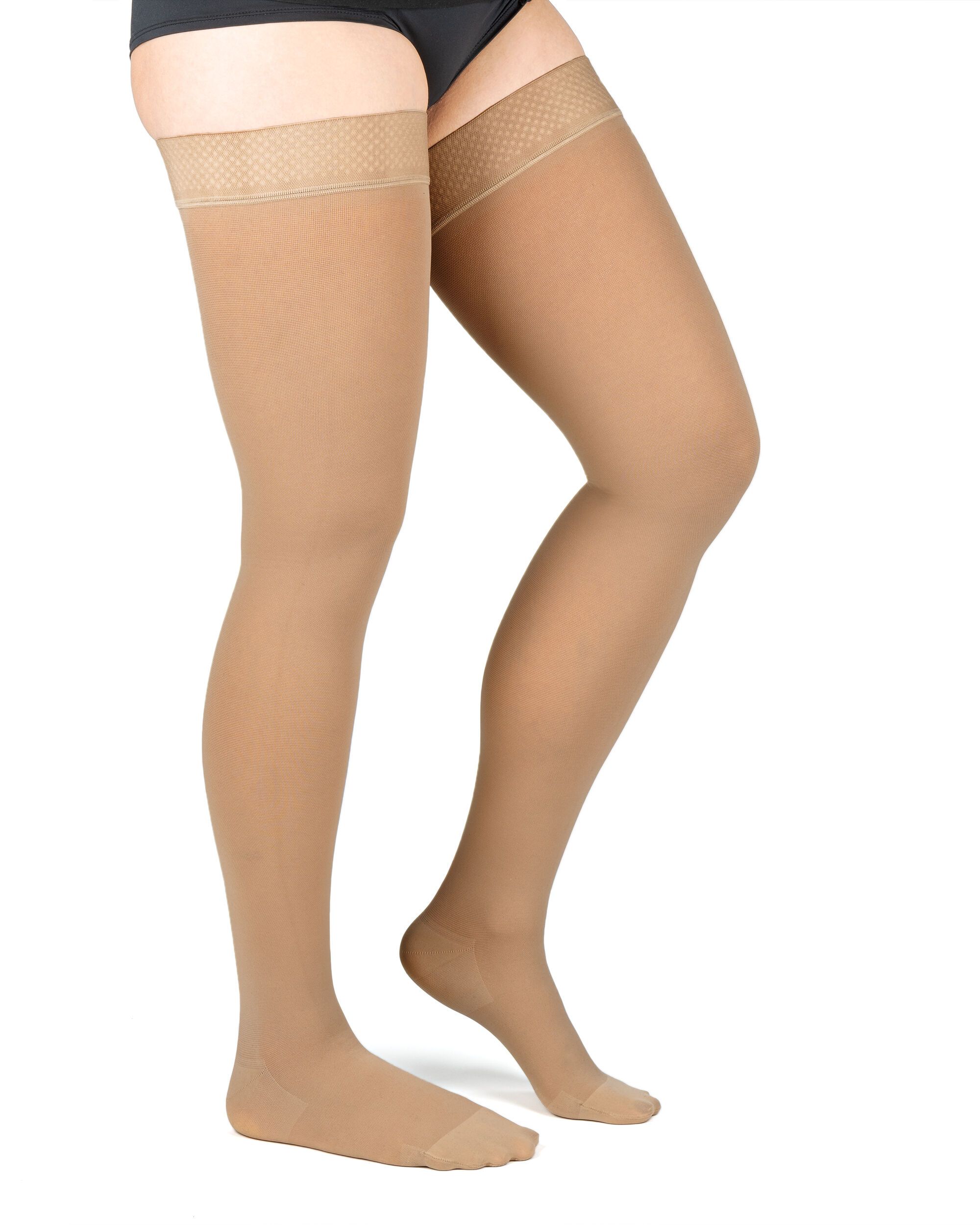 Beine einer Person mit Kompressionsstrümpfen. Beige Strümpfe bis zum Oberschenkel.