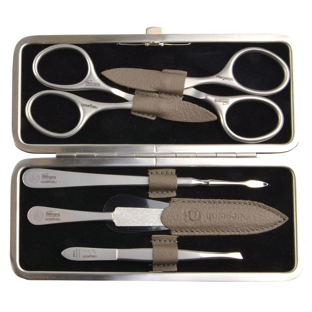 Geöffnetes Etui mit Maniküre-Werkzeugen. Enthält Schere, Pinzette, Nagelfeile und weitere Instrumente. Werkzeuge aus Metall.