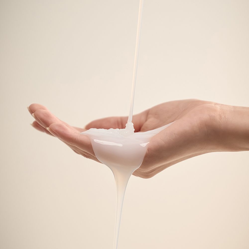 Hand, die eine Flüssigkeit empfängt. Flüssigkeit wird aus einer Öffnung gegossen.