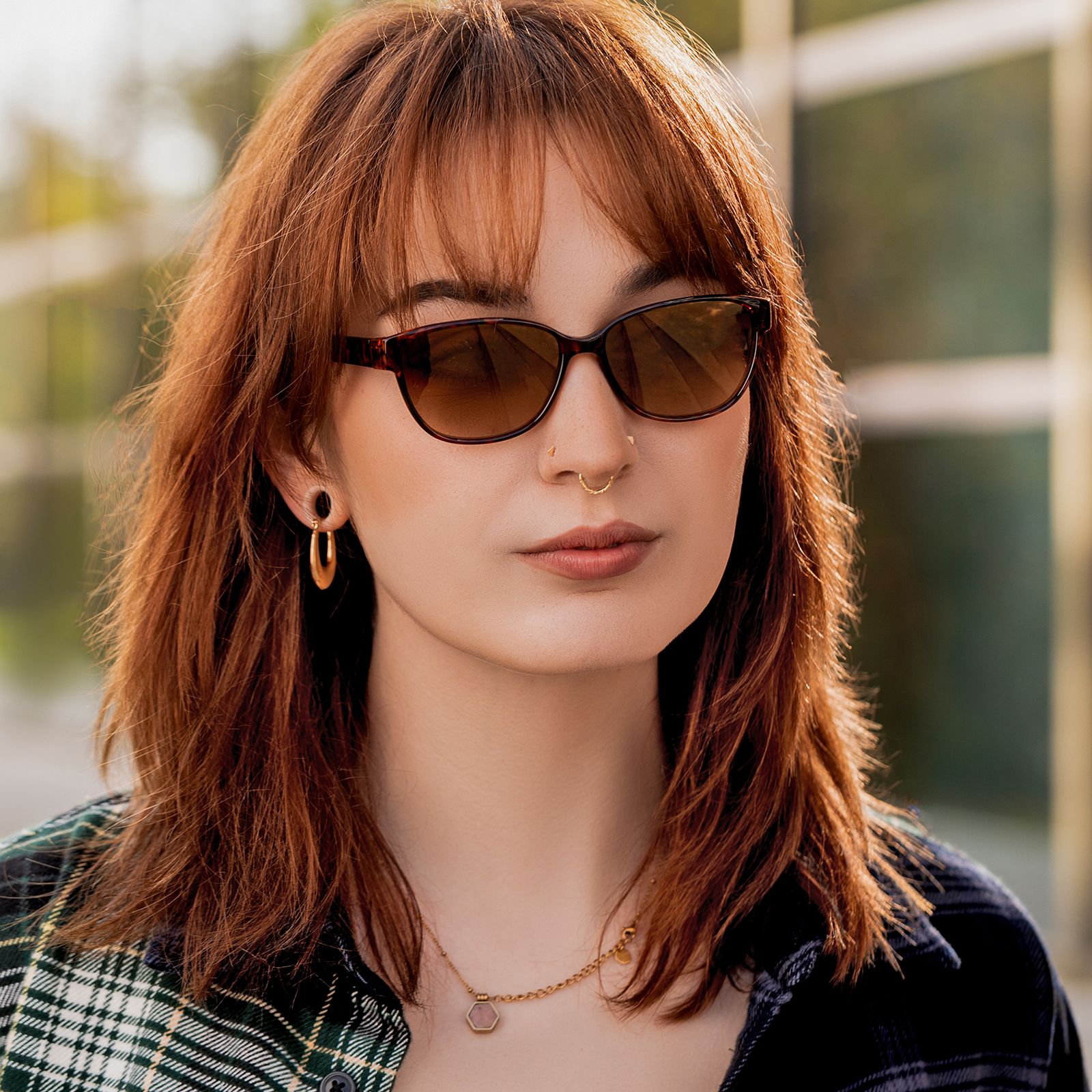 Frau mit Sonnenbrille. Schildpatt-Muster-Rahmen. Nahaufnahme, vor unscharfem Hintergrund.