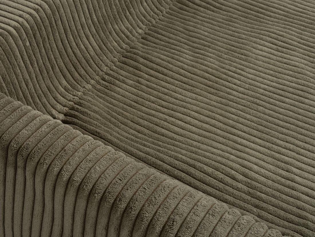Nahaufnahme des Cordbezugs eines Hundebetts. Olivgrüne Farbe, geriffelte Textur. Stoffdetails.