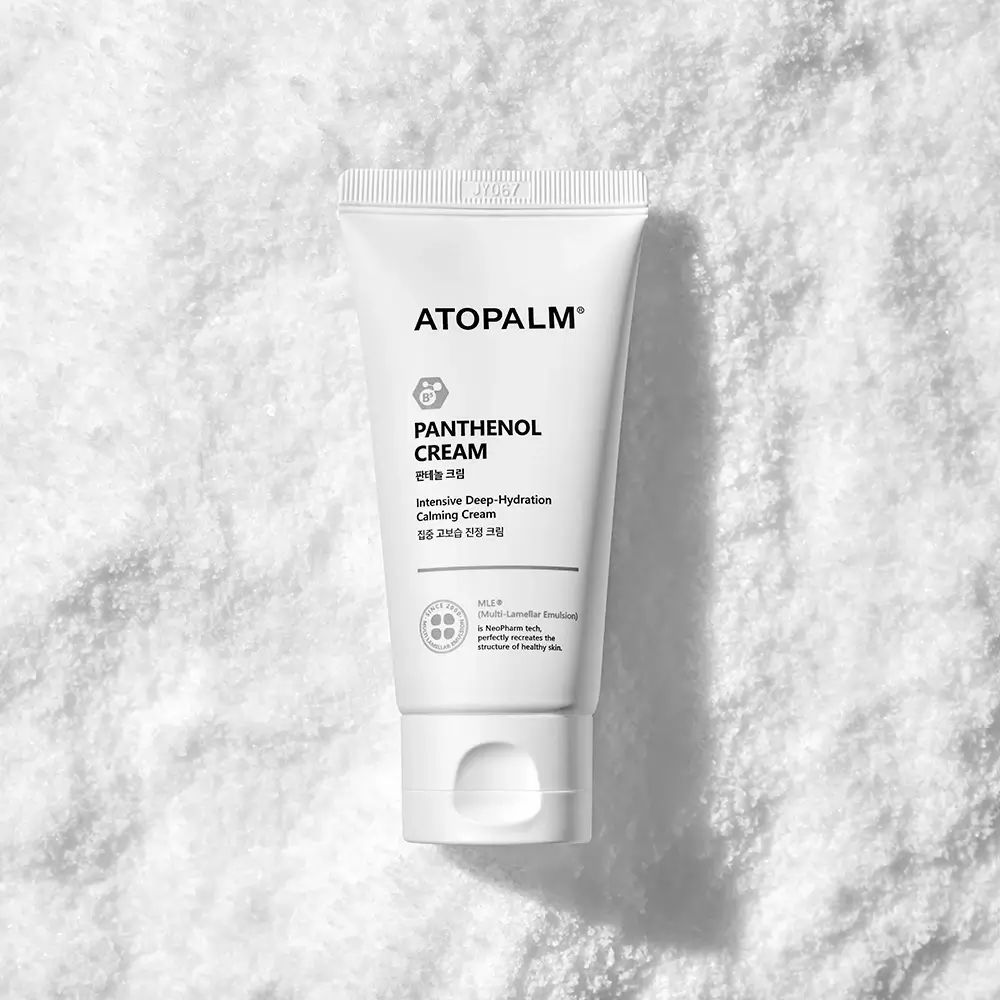 Weiße Tube mit Produktnamen und Logo, auf weißem Untergrund. Aufschrift: ATOPALM, Panthenol Cream.