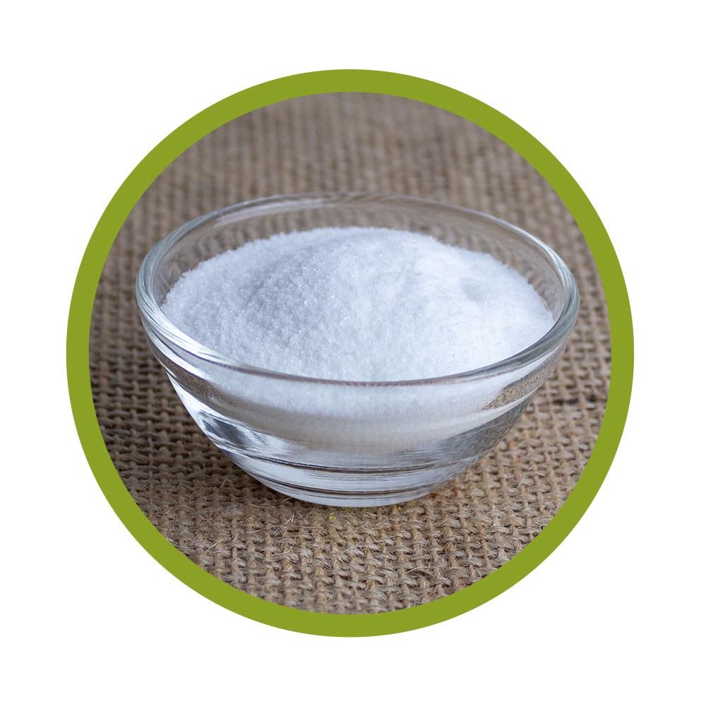 Runde Glasschale mit weißem Pulver auf beigem Untergrund.