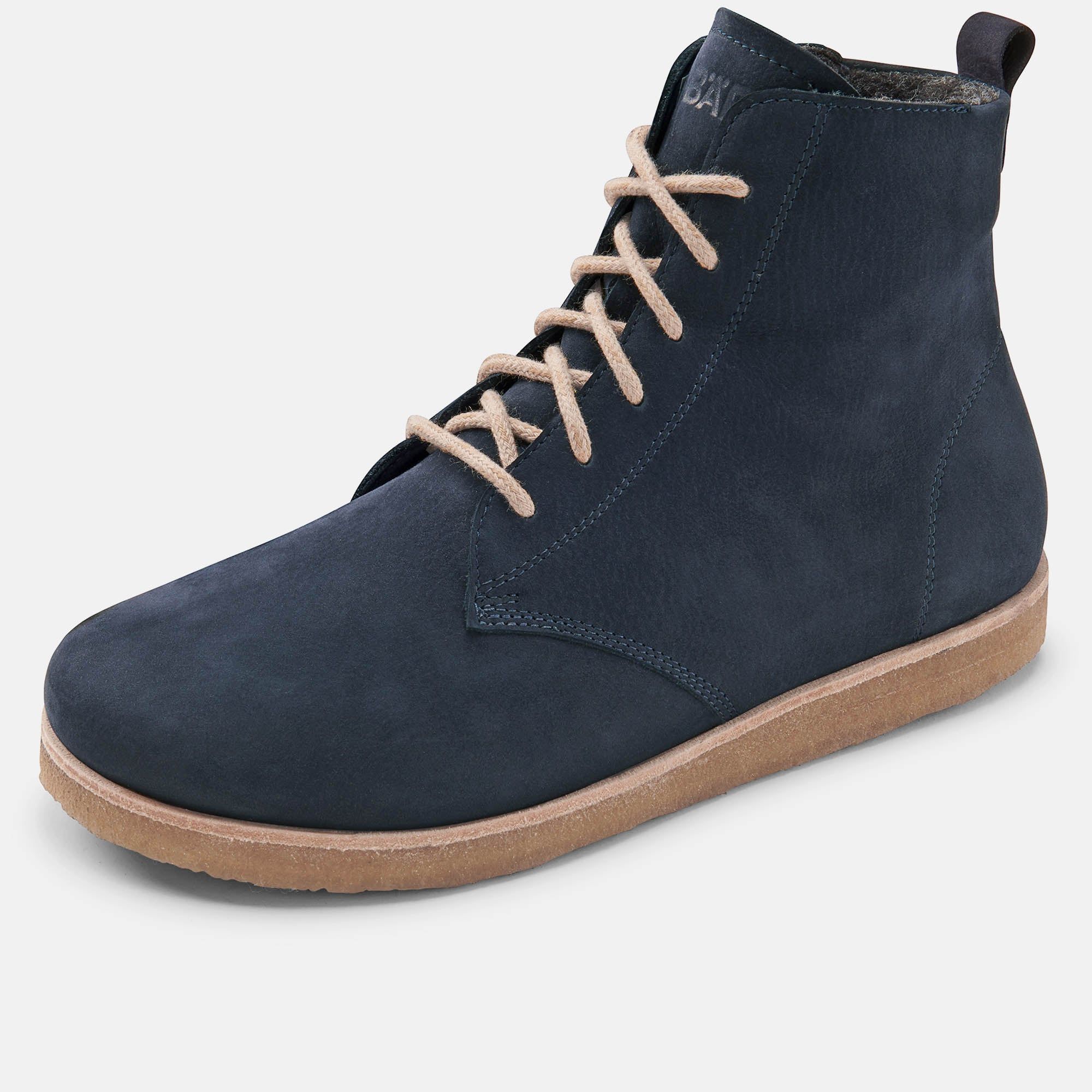 Blaue Stiefelette mit Schnürsenkeln. Beige Schnürsenkel und Sohle. Hellgrauer Hintergrund.