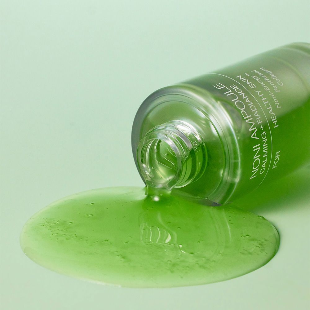 Grüne Flüssigkeit aus einem umgekippten Celimax Noni Energy Ampoule Fläschchen.