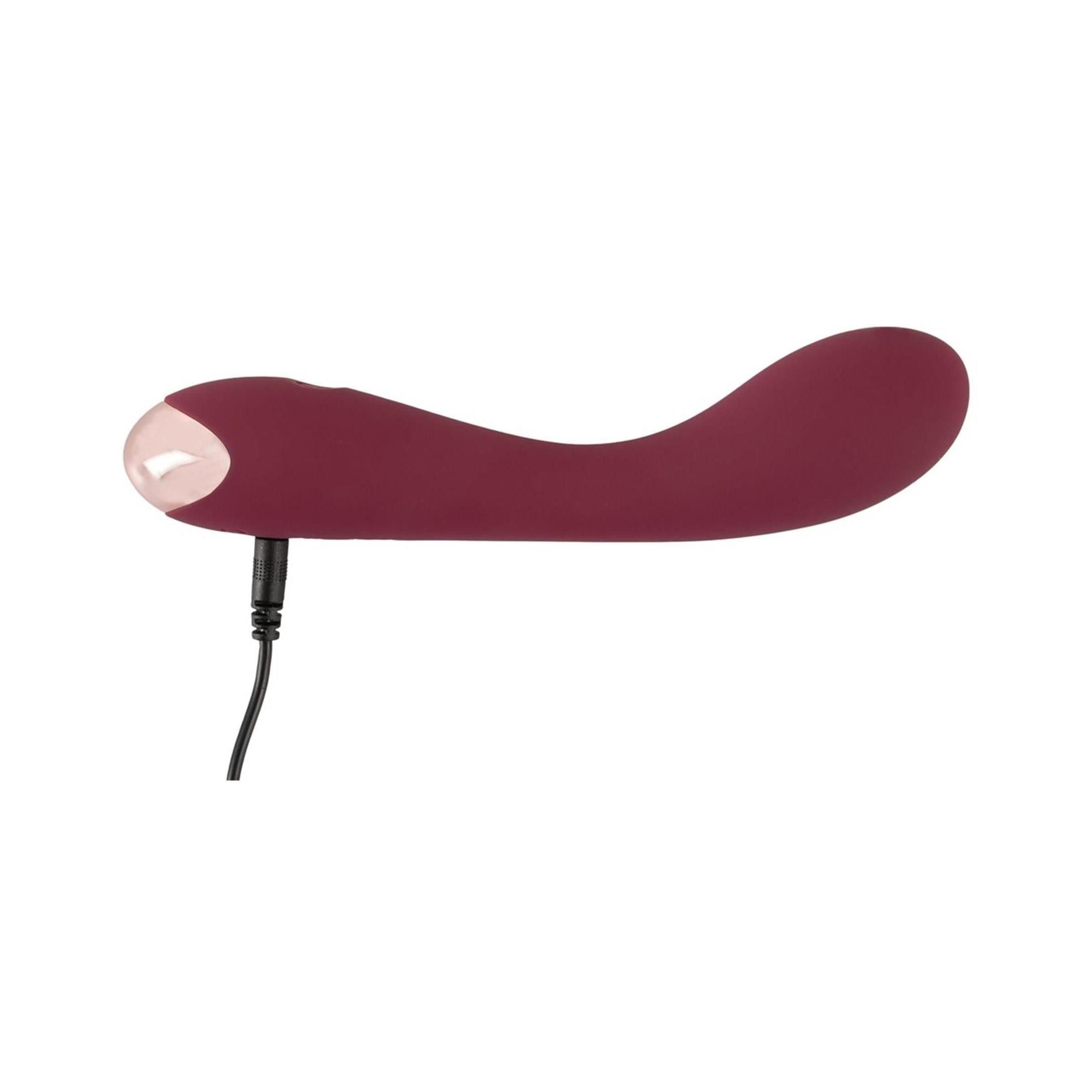 Burgunderfarbener Vibrator mit Ladeanschluss. Metallspitze sichtbar.