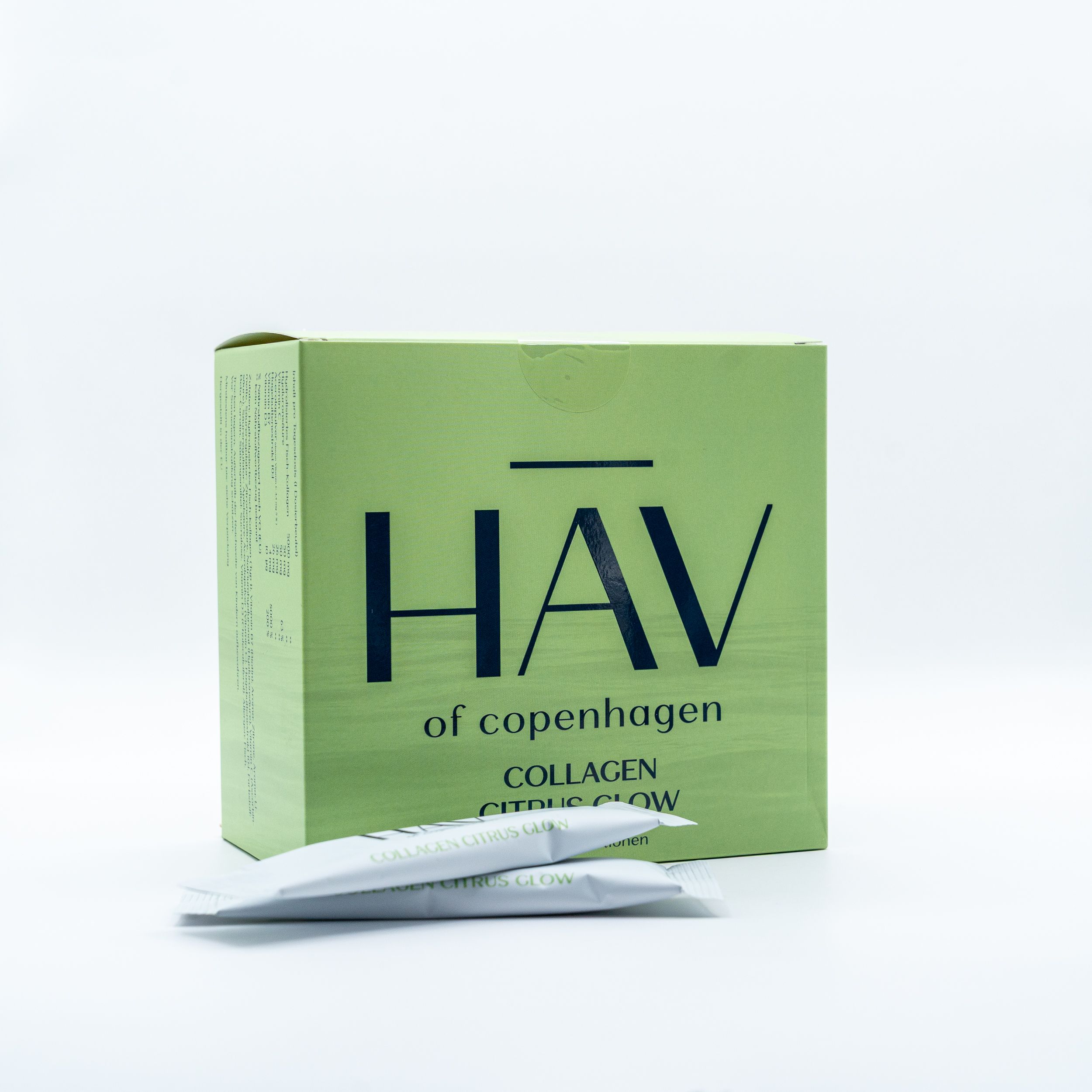 Grüne Schachtel HAV of Copenhagen Collagen Citrus Glow. Zwei Einzelportionen liegen daneben. Logo und Produktname sichtbar.