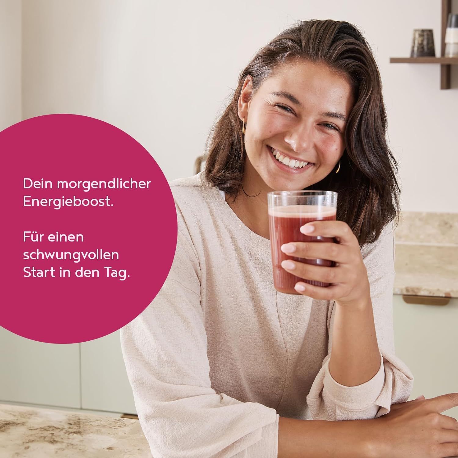 Frau hält Glas mit rotem Getränk. Text: Dein morgendlicher Energieboost. Für einen schwungvollen Start in den Tag.