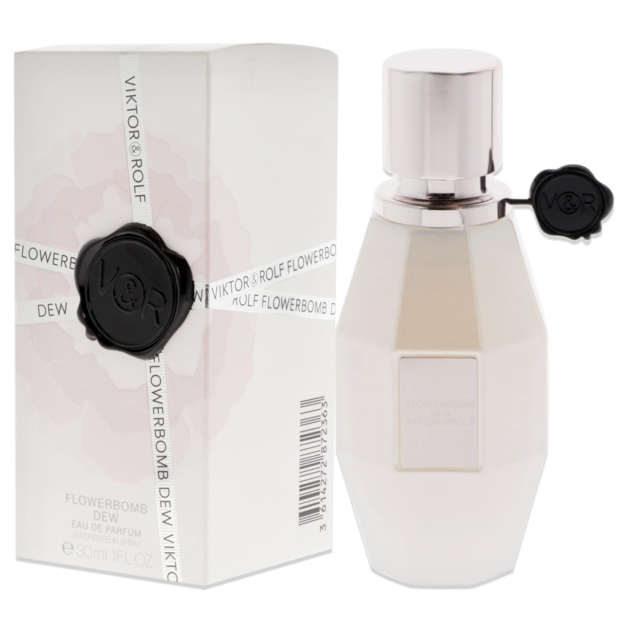 Parfümflasche und Verpackung. Flasche weiß, achteckig, mit silbernem Verschluss und schwarzem Anhänger. Verpackung weiß mit Text.