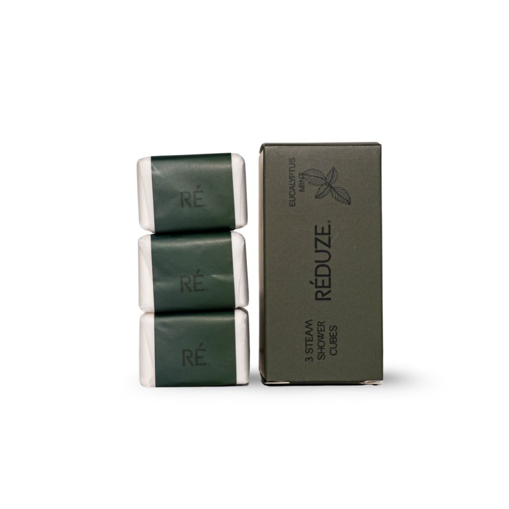 Drei Duschwürfel und eine grüne Box mit "RÉDUZE"-Logo. Text: "EUCALYPTUS MINT" und "3 STEAM SHOWER CUBES".