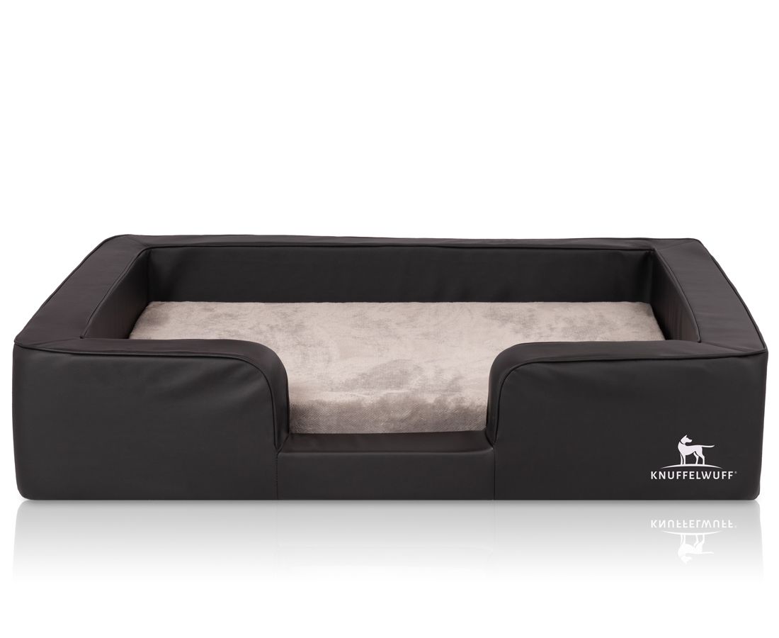 Schwarzes orthopädisches Hundebett mit erhöhtem Rand und beigem Liegebereich. Logo: Knuffelwuff.