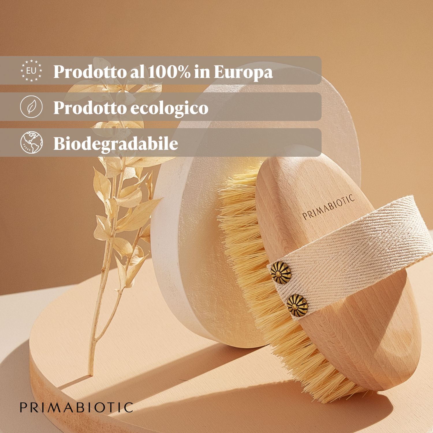 Körpermassagebürste mit Holzgriff und Stoffschlaufe. Borsten. Aufschrift: "PRIMABIOTIC". Text: "Prodotto al 100% in Europa", "Prodotto ecologico", "Biodegradabile".