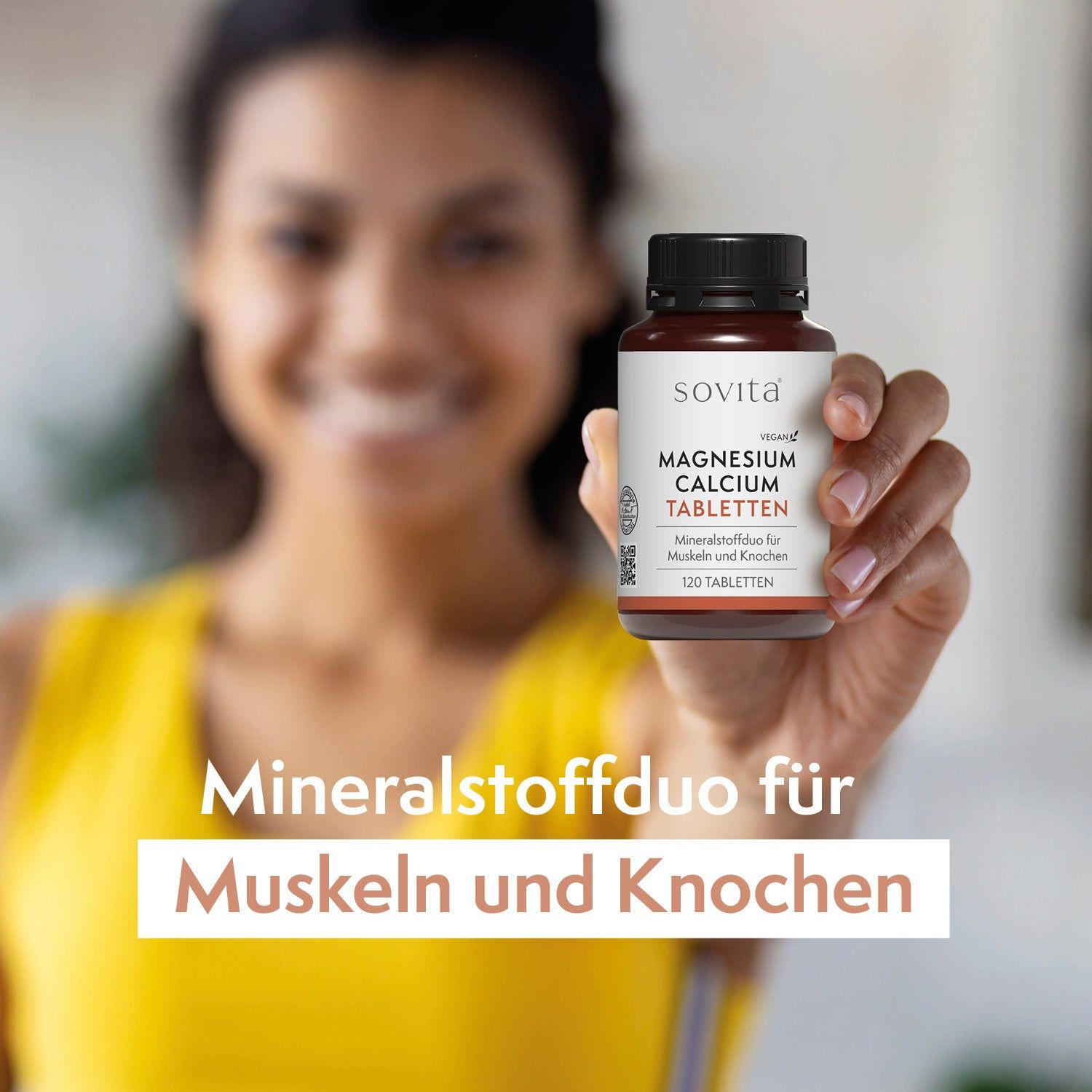 Frau hält eine Flasche SoVita® Magnesium Calcium Tabletten. Text: Mineralstoffduo für Muskeln und Knochen. Gelbes Top.