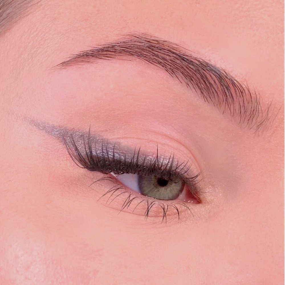 Auge mit grauem Eyeliner. Wimpern und Augenbrauen. Hautton rosa.
