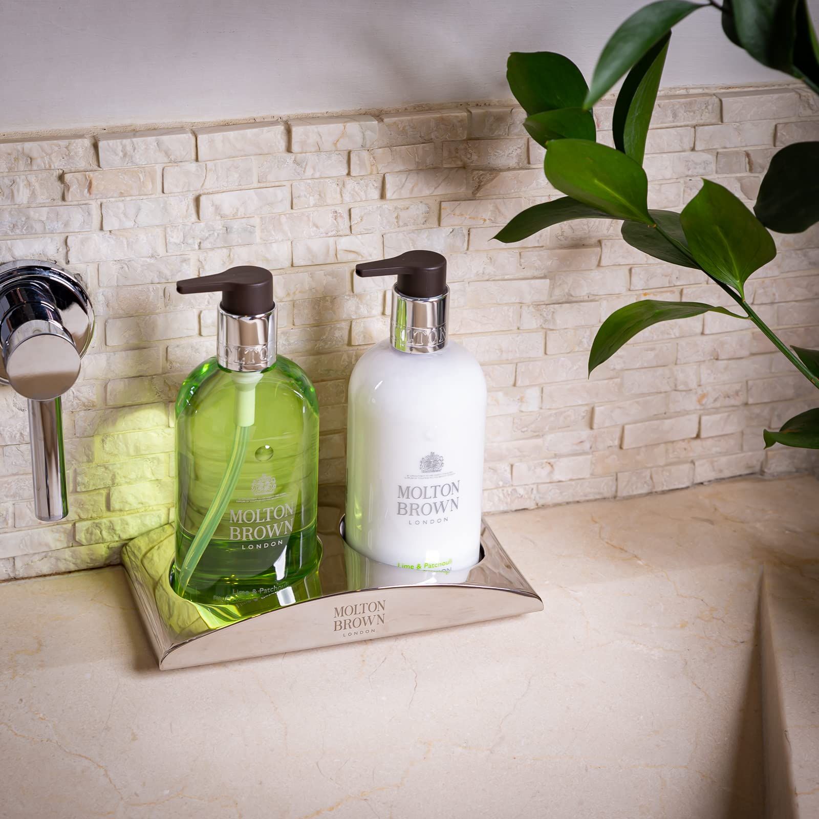 Zwei Seifenspender auf einer Ablage. Molton Brown. Links: Grün. Rechts: Weiß. Auf Waschbecken.