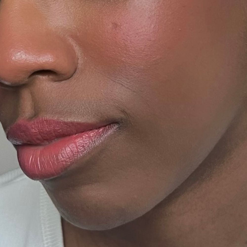 Nahaufnahme eines Gesichts mit Lippen und Wangen in Rosa. Hautton. Lippenstift aufgetragen.