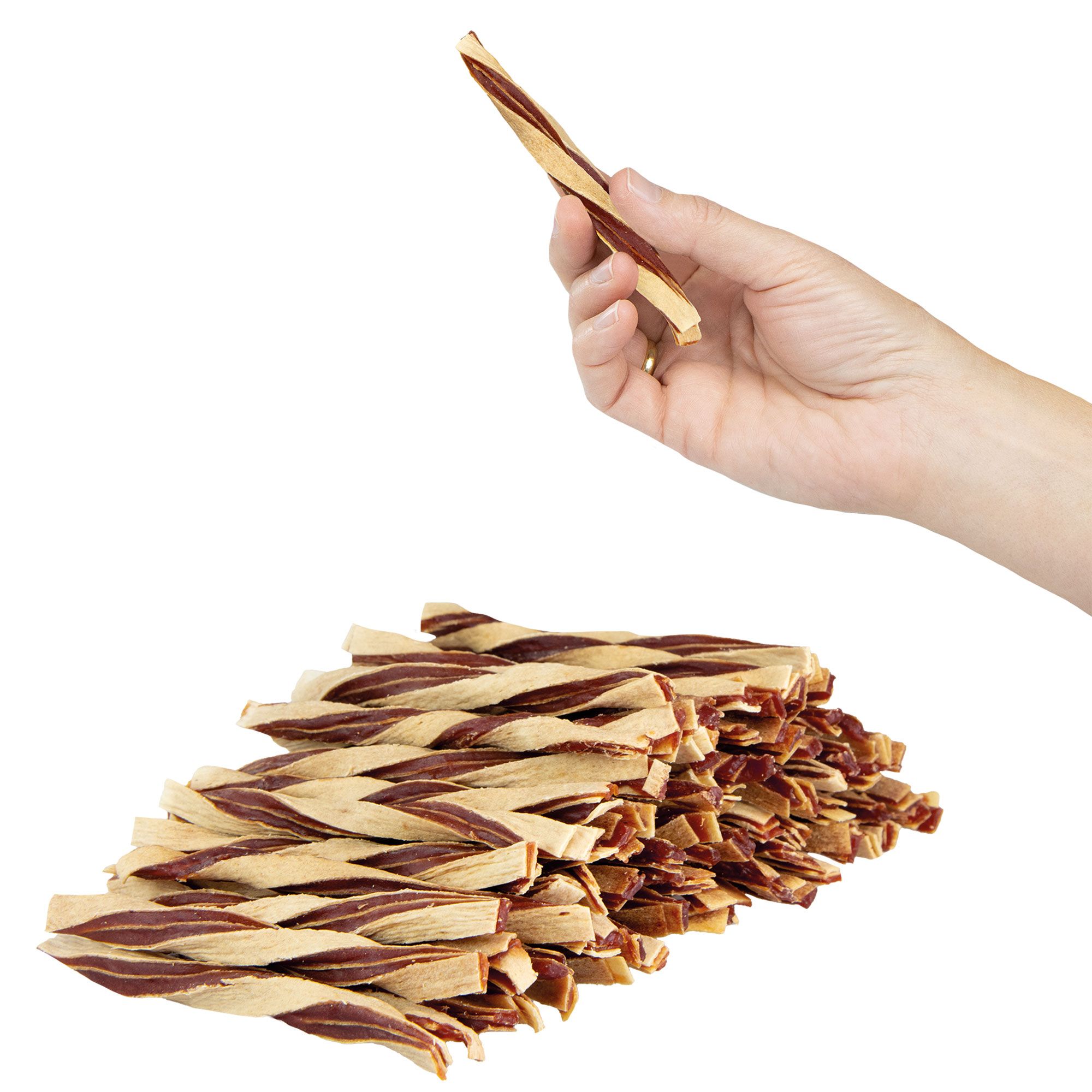 Gedrehte Hundesnacks, beige und braun. Eine Hand hält einen Snack. Ein Haufen Snacks liegt darunter.