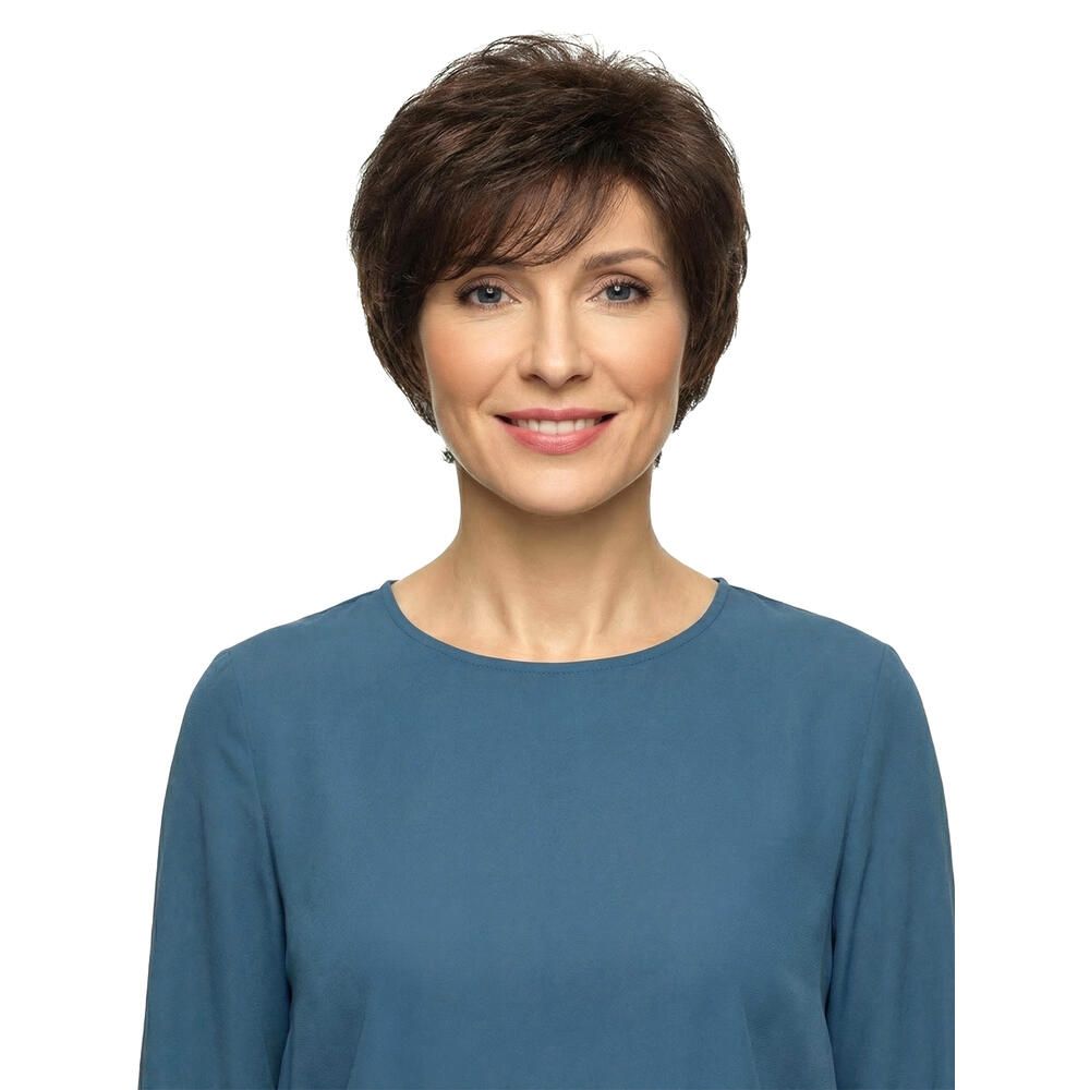 Kurzhaarperücke, braun, mit Pony, auf einer Frau. Die Frau trägt ein blaues Oberteil und lächelt.