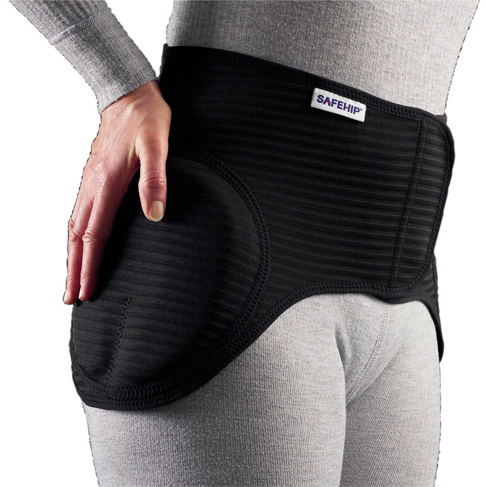 Schwarzer SAFEHIP® Active Gürtel mit Protektoren. Rippenstruktur, gepolsterte Bereiche. Auf Hüfte getragen, Hand am Produkt.