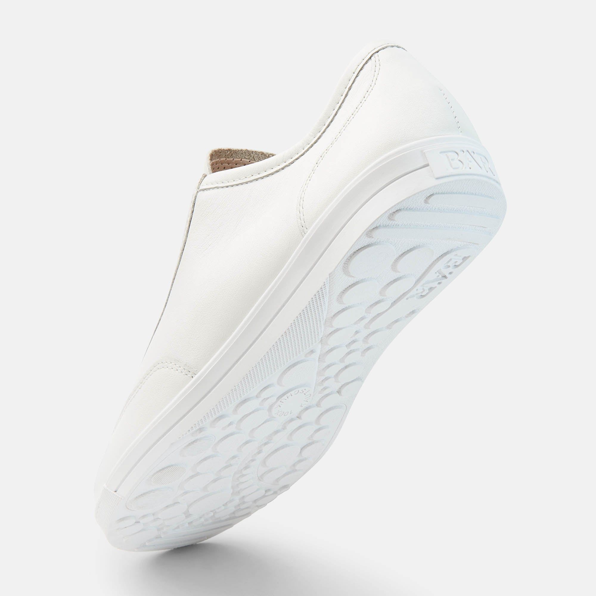 Weißer Schnürschuh von unten. Sohle mit Muster. Glattes Leder, helle Schnürsenkel. Sohle und Schuh in Weiß.