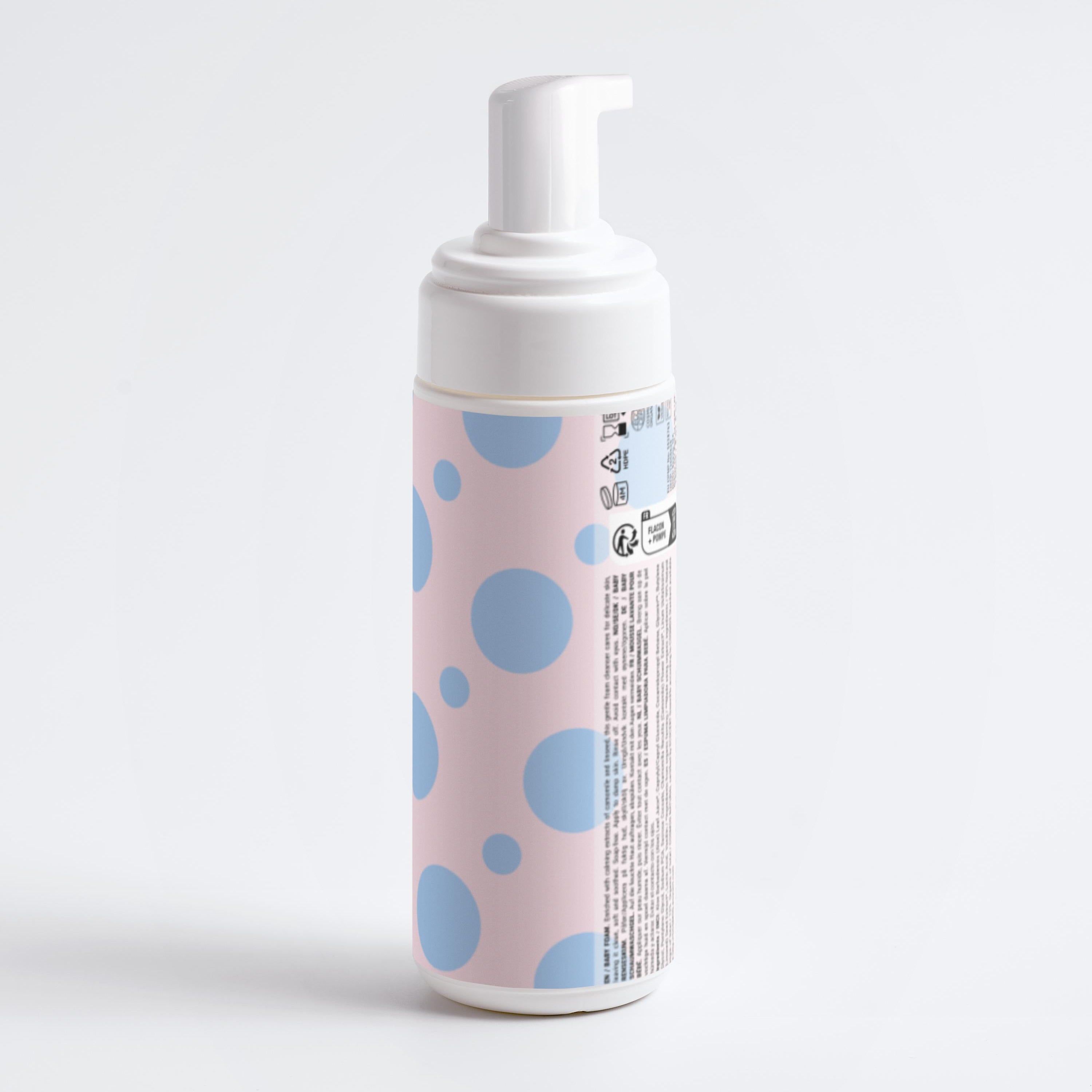 Rückseite einer Reinigungsschaum-Flasche. Weiße Flasche mit rosa Etikett und blauen Punkten. Text und Symbole.